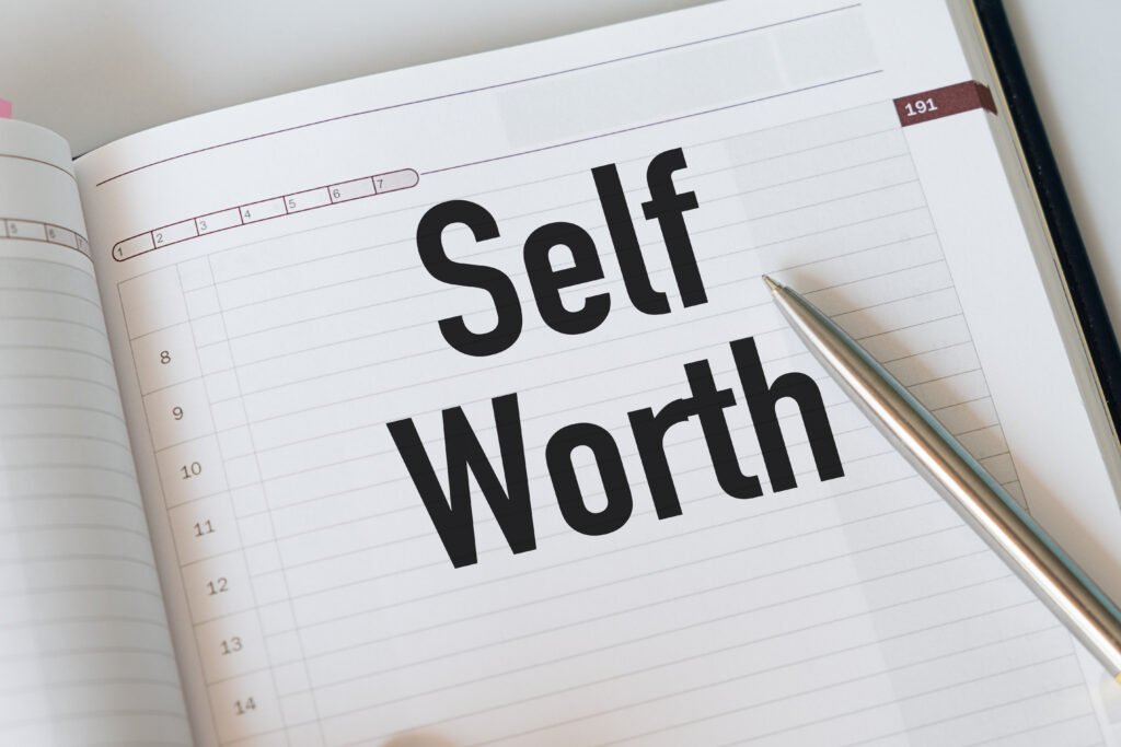Paper notebook with handwritten text SELF WORTH, refers to self-love, being confidence with self-esteem - giving yourself respect, dignity and understanding